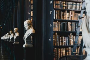 Library with sculptures and shelves filled with books, showcasing a blend of art and literature.